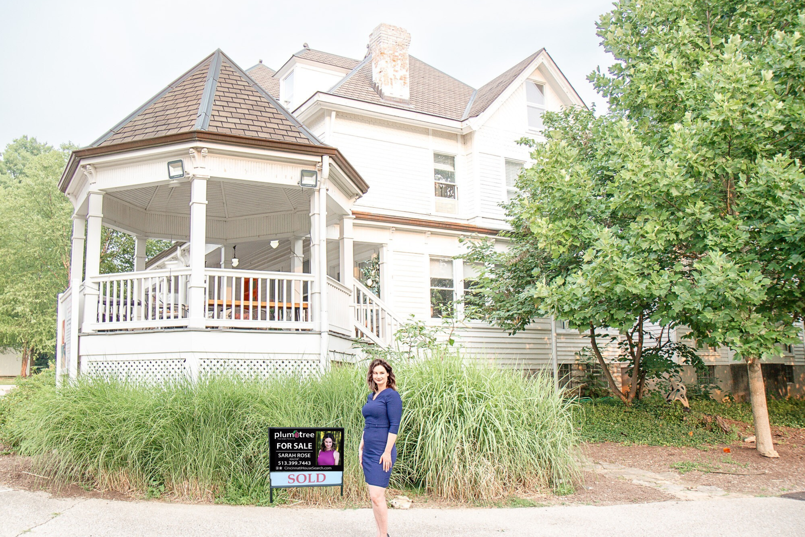 Front exterior of a white Cincinnati-area home with a covered porch and landscaped lawn